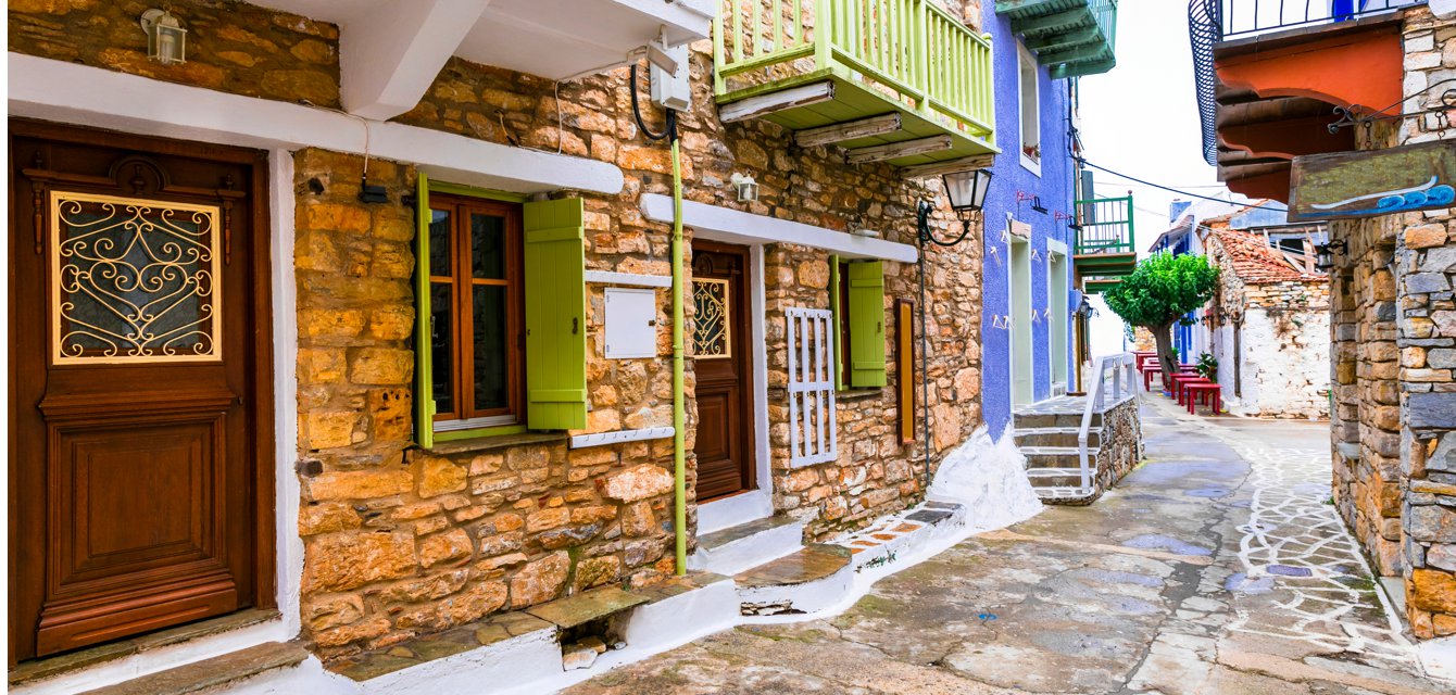 Picturesque colorful houses in a cobblestoned street in Alonissos, Greece