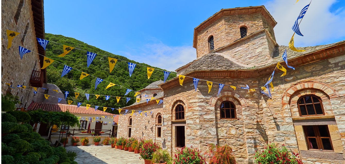 Impressive church of Evaggelistria in Skiathos, Greece decorated with flags on a festive day
