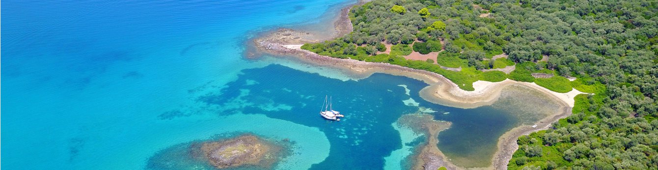 Astonishing panoramic view of a sailing yacht in Evia, Greece surrounded by green and azure landscapes