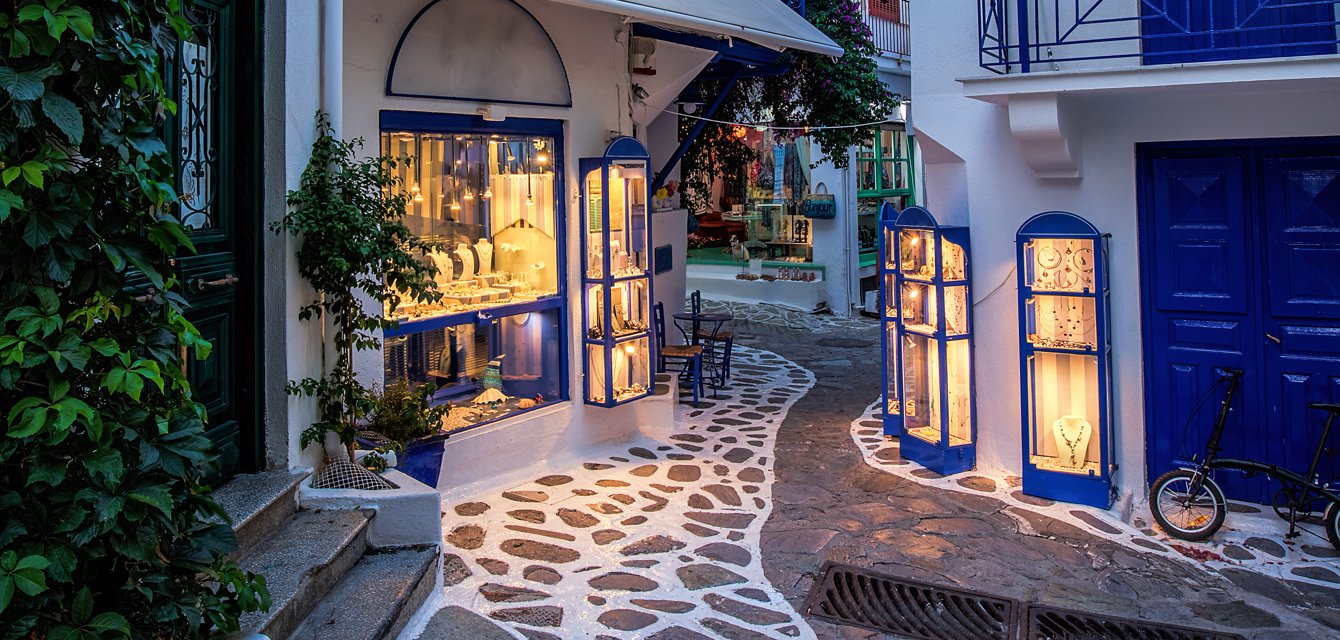 Picturesque little cobblestone alley in white and blue shades in Skiathos, Greece